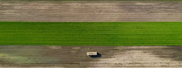 Aerial view of precision agriculture with tractor in green field